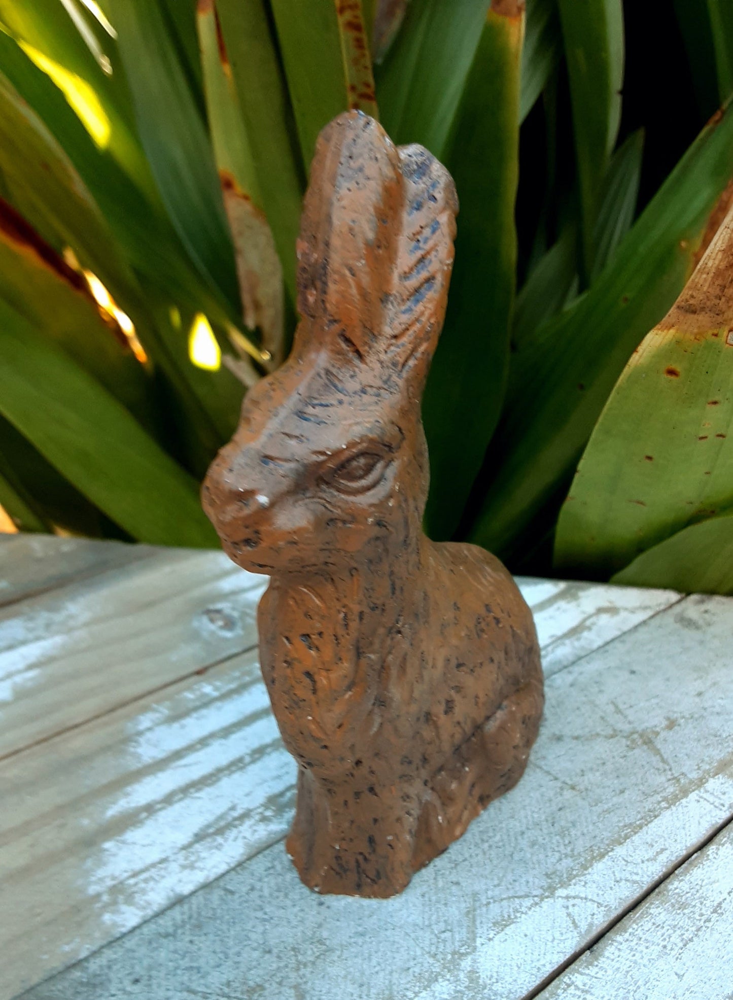 Sweet chocolate bunny rabbit made from resin  measures approximately 2.5" across x 3.5" high  long pointed upright ears  three leaf clover on one side and I think there are flowers underfoot  in good vintage condition  weight is approx 1 pound